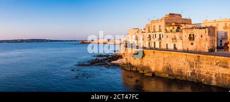 Panorama-Foto von Ortigia Altstadt bei Sonnenaufgang, mit Burg Ortigia (Castello Maniace, Castle Maniace) im Hintergrund, Syrakus (Siracusa), UNESCO-Weltkulturerbe, Sizilien, Italien, Europa Stockfoto