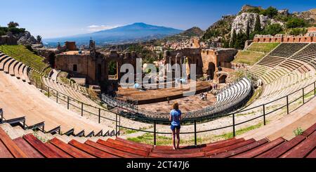 Panorama-Foto von einem Touristen Besuch Teatro Greco aka Taormina griechischen Theater, mit Vulkan Ätna hinter, Sizilien, Italien, Europa Stockfoto