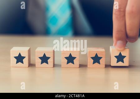 Ausgezeichnete Bewertung Abstimmung durch Kundenerfahrung mit Hand Putting höchste Rate fünf Sterne. Beste Dienstleistungen Konzept. Stockfoto