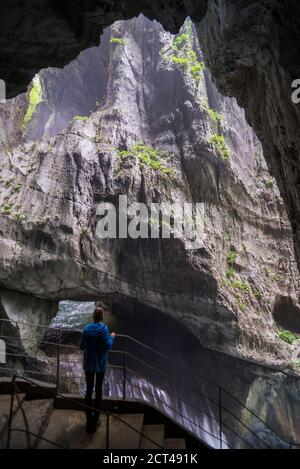 Tourist in den Höhlen von Skocjan, Slowenien, Blick auf den Wasserfall am Fuße des "Großen Tals" (Velika Dolina), Karstregion Sloweniens, Europa Stockfoto