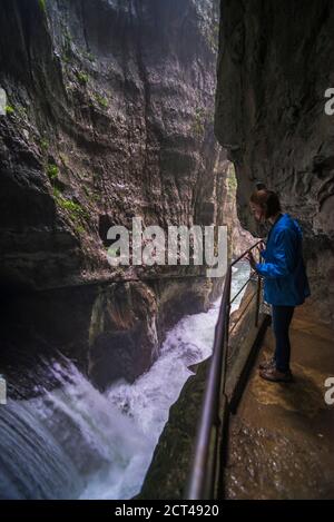 Tourist in den Höhlen von Skocjan, Slowenien, Blick auf den Wasserfall am Fuße des "Großen Tals" (Velika Dolina), Karstregion Sloweniens, Europa Stockfoto