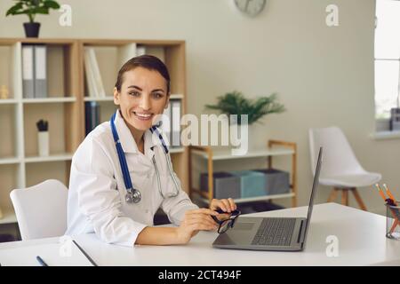 Frau Arzt Blick auf Kamera während Online-Meeting auf Laptop Stockfoto
