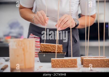 Nahaufnahme der Küchenchefs, die Kuchen und Desserts zubereiten Schokoladenglasur Stockfoto
