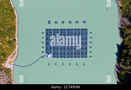 Sonnenkollektoren des ersten hochgelegenen schwimmenden Solarkraftwerks der Schweiz von oben, Lac des Toules, Bourg-Saint-Pierre, Wallis, Schweiz Stockfoto