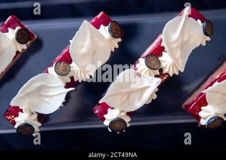 Catering-Tisch mit in Scheiben geschnittenen Schokoladenkuchen mit frischen Himbeeren dekoriert Und Muttern Stockfoto