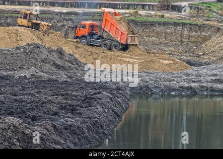 Dumper LKW entladen Sand auf Baustelle mit Wasser Stockfoto