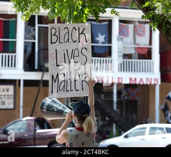 Kennesaw, Georgia, USA. Juni 2020. Ein Protestor mit einem Megaphon hält ein Schild mit der Aufschrift "Black Lives Matter" während einer Demonstration vor Wildmans Civil war Surplus Shop in der Innenstadt Kennesaw. Quelle: Robin Rayne/ZUMA Wire/Alamy Live News Stockfoto