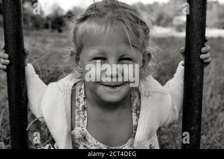 Nahaufnahme schwarz-weiß Porträt von niedlichen liebenswert lächelnd kaukasischen Kind. Porträt eines glücklichen Kindes in der Natur. Happy Childhood Konzept. Das Baby