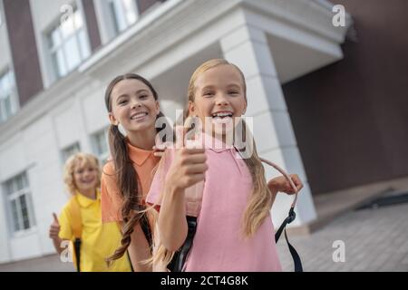 Schulkinder treffen sich nach dem Unterricht im Schulhof und fühlen sich fröhlich Stockfoto