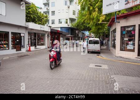 Männlich / Malediven - 10. August 2019: muslimische Frau mit Hijab auf dem Motorrad in der Hauptstadt der malediven Stockfoto