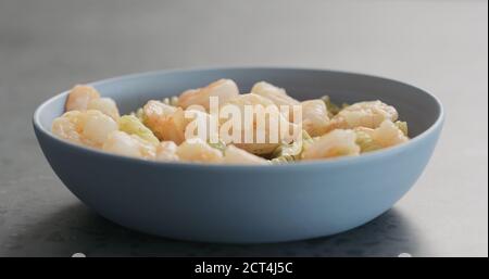 Pesto fusilli Pasta mit Garnelen in blauer Schale auf betontem Hintergrund, breites Foto Stockfoto