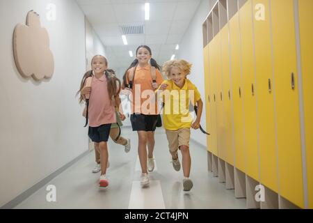 Schüler, die nach dem Unterricht im Schulkorridor laufen Stockfoto