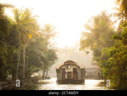 Hausboot-Touristenbootfahrt auf einem Excusrion in den Kerala Backwaters bei Sonnenuntergang in der Nähe von Alleppey, Alappuzha, Indien Stockfoto