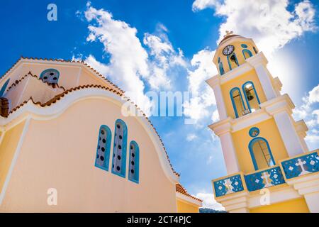 Traditionelle orthodoxe gelbe Kirche mit roter Ziegelkuppel im Dorf Diafani, Insel Karpathos, Griechenland Stockfoto