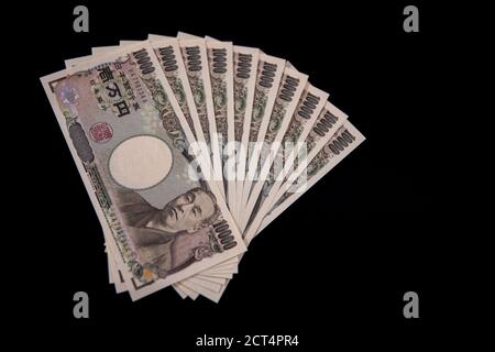 Japanische Währung 100,000 Yen auf schwarzem Hintergrund Stockfoto