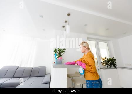Attraktive Frau, die Möbel in der Küche mit einem Lappen reinigen Stockfoto