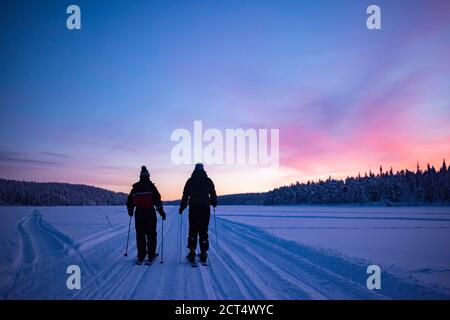 Skifahren auf dem gefrorenen See bei Torassieppi bei Sonnenuntergang, Lappland, Finnland Stockfoto