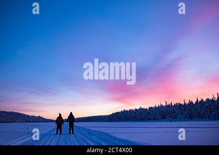 Skifahren auf dem gefrorenen See bei Torassieppi bei Sonnenuntergang, Lappland, Finnland Stockfoto