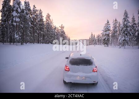 Autofahren auf vereisten, schneebedeckten Straßen auf einer Straße Reise während der Reise in Lappland innerhalb des Polarkreises in Finnland Stockfoto