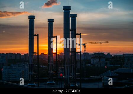 Modernes Dach mit Lüftungsrohren am Abend Sonnenuntergang Stockfoto