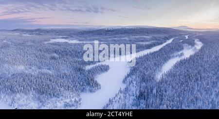 Luftbild von gefrorenen Fluss und Schnee bedeckten Wald Winterlandschaft Zeigt erstaunliche Lappland Landschaft in Skandinavien in Finnland Drohne Stockfoto