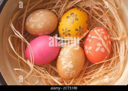 Bemalte Ostereier auf einem Bett aus Stroh in einem Schüssel Stockfoto