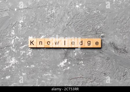 Wissenswort auf Holzblock geschrieben. Wissenstext auf Zementtisch für Ihr Design, Konzept. Stockfoto