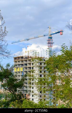Bau eines mehrstöckigen Gebäudes. Hochhaus Baukran gegen einen blau bewölkten Himmel. Selektiver Fokus. Stockfoto