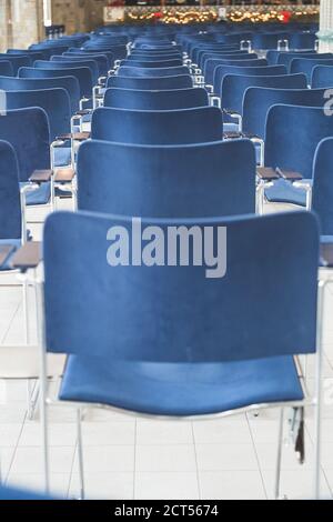 Back view of the rows of blue chairs in a conference hall; no people, selective focus Stockfoto