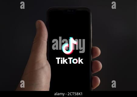 Der Bildschirm eines Smartphones mit TikTok App-Logo auf Schwarzer Hintergrund Stockfoto