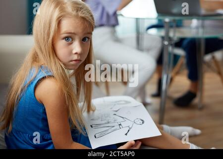 Adorable kaukasischen Kind Mädchen halten Zeichnung der Eltern getrennt, sie gehen zu geschieden werden. Familie, Kinder, Scheidung, Vormundschaft Konzept Stockfoto