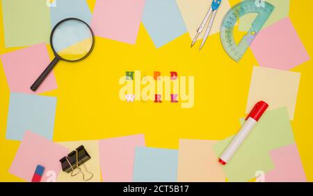 Das Konzept der Motivation, Arbeit. Die Wörter HARTE ARBEIT in der Mitte auf einem gelben Hintergrund, farbige Buchstaben. Rahmen aus leeren Notizpapieren und Briefpapier. Stockfoto