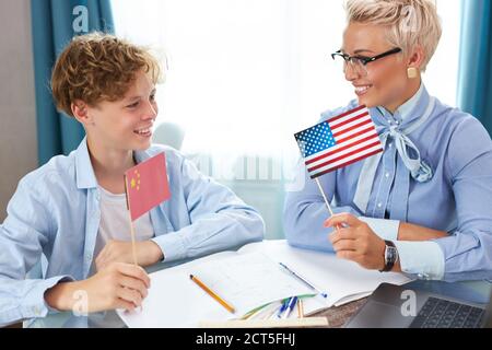 kaukasische englisch Lehrerin Frau hilft Jungen Unterricht zu Hause zu lernen, Tutor hilft Schuljunge Unterricht zu lernen, überprüft die Hausaufgaben des Kindes. Individuelle Home-Bas Stockfoto