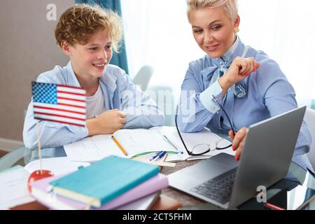 kaukasische englisch Lehrerin Frau hilft Jungen Unterricht zu Hause zu lernen, Tutor hilft Schuljunge Unterricht zu lernen, überprüft die Hausaufgaben des Kindes. Individuelle Home-Bas Stockfoto