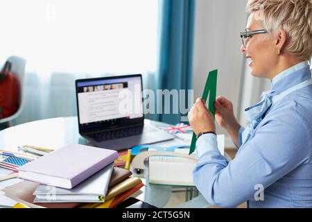 Weibliche Lehrerin halten Sprachtherapie-Sitzung mit Schülern online, lehrt Aussprache und Sprachschwierigkeiten, mit Laptop Stockfoto