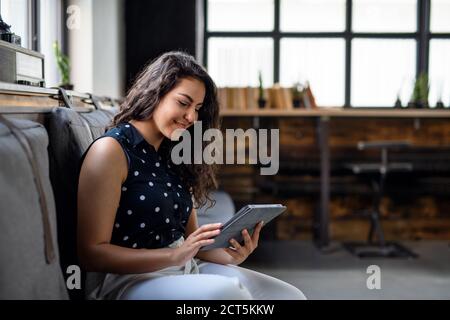 Porträt der jungen Geschäftsfrau drinnen im Büro, mit Tablet. Stockfoto
