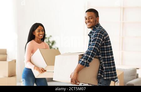 Schwarzes Millennial-Paar mit Kartons in ihrer neuen Wohnung Am Umzugstag Stockfoto