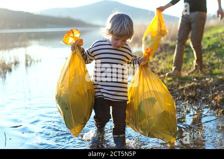 Vater mit kleinen Sohn sammeln Müll im Freien in der Natur, plogging Konzept. Stockfoto