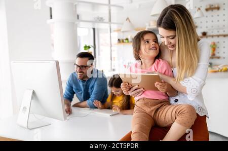Eltern helfen Kindern, die online zu Hause studieren. Lockdown und Online-Schule, Technologie-Konzept. Stockfoto