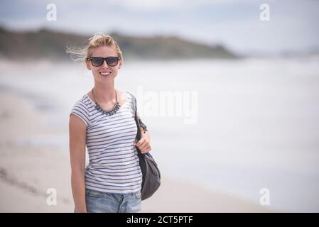 Tourist am Rarawa Beach, einem beliebten und schönen weißen Sandstrand in Northland Region, Nordinsel, Neuseeland Stockfoto