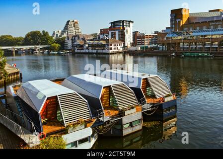 Moderne Hausboote liegen an der Themse in Kingston upon Thames, Greater London, gegenüber von John Lewis und anderen Geschäften am Wasser Stockfoto