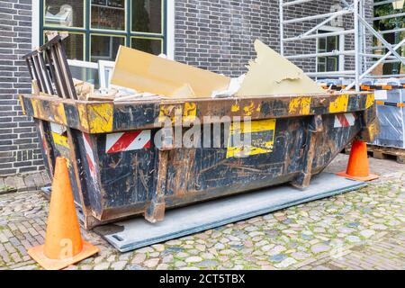 Holländischer Abfallcontainer in einer alten Straße auf einem Haus Renovierung Baustelle Stockfoto