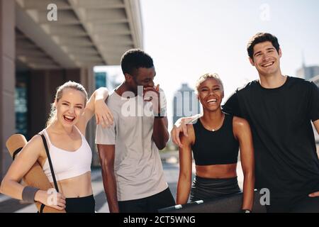 Multirassische Freunde, die nach dem Training im Freien stehen. Gesunde junge Menschen stehen nach dem Training zusammen. Stockfoto