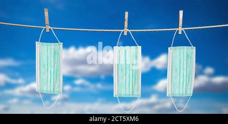 Coronavirus Spread Prevention Measure Konzept. Wäscheklammern halten drei Einweg-OP-Masken zum Trocknen am Seil. Blauer Himmel Hintergrund. 3d-Illustrationen Stockfoto