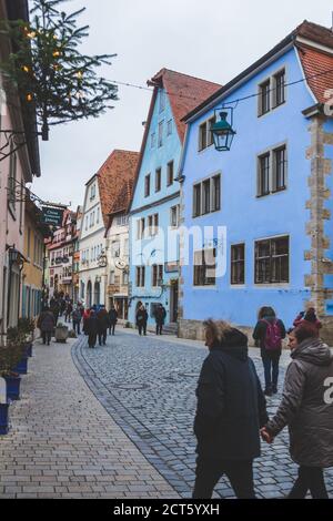 Rothenburg/Deutschland-1/1/19: Menschen, die an traditionellen bunten Häusern in der Altstadt von Rothenburg ob der Tauber vorbeilaufen. Die Stadt ist eine bekannte älteste Stockfoto