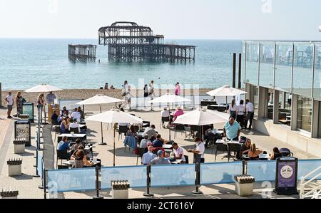 Brighton UK 21. September 2020 - Besucher nutzen das sonnige Wetter in der West Beach Bar & Kitchen am Brighton Strand und am Meer, da es ab Mittwoch in ganz Großbritannien abkühlen wird. : Credit Simon Dack / Alamy Live News Stockfoto