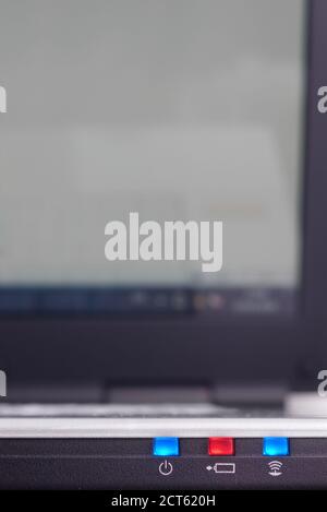 Nahaufnahme der Notebook-LEDs mit Strom, Akku und wi-Fi-Status mit unscharfem Monitor Stockfoto