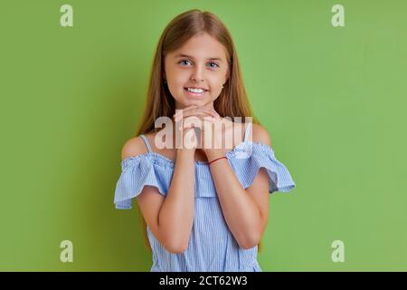 Porträt von niedlichen langhaarigen kaukasischen Mädchen posiert bei der Kamera, liebenswert Mädchen Blick in die Kamera, hat sie geheimnisvollen Blick. Isoliert grünen Hintergrund Stockfoto