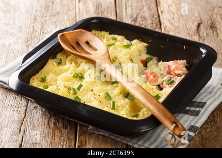 Fish Pie, auch bekannt als Fisherman's Pie, ist ein traditionelles britisches Gericht Pie aus Kartoffelpüree und Lachs Nahaufnahme in einer Backform auf dem Tisch. Stockfoto