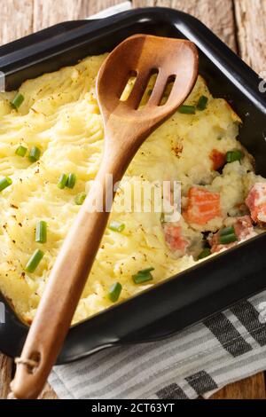 Fischauflauf mit Kartoffelpüree und Lachs aus nächster Nähe in einer Auflaufform auf dem Tisch. Vertikal Stockfoto